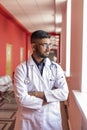 Tired young indian doctor or on break in COVID hospital wears glasses and a stethoscope, in a white coat