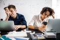 Tired young employees looking at laptops screens