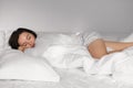 Tired young european female sleeping on white bed, enjoying sweet dreams, weekend or free time, vacation Royalty Free Stock Photo