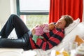 Tired young father holding his sleeping newborn baby daughter on arms in hospital Royalty Free Stock Photo
