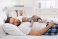 Tired young father sleeping with his baby in bed at home Royalty Free Stock Photo