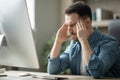 Tired Young Freelancer Guy Having Headache While Working In Home Office Royalty Free Stock Photo