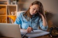 Tired young girl sitting at the table in her office and plans works tasks. Working day concept. Studying online. Freelancer Royalty Free Stock Photo