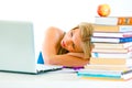 Tired young girl sleeping on table with laptop Royalty Free Stock Photo
