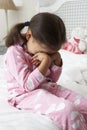 Tired Young Girl Wearing Pajamas Sitting On Bed Royalty Free Stock Photo