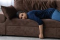 Tired Indian woman lying on sofa feeling lazy