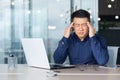 An Asian businessman feels severe headache, Holds his head with his hands Royalty Free Stock Photo