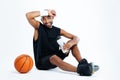 Tired young man basketball player sitting and drinking water Royalty Free Stock Photo