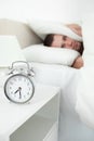 A tired young man covering his ears with a pillow Royalty Free Stock Photo