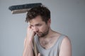 Tired young man with mop on white background Royalty Free Stock Photo