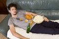 Sleeping yong man relax after work, beer and popcorn and chips Royalty Free Stock Photo