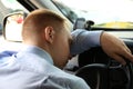 Tired young man sleeping on steering wheel in car Royalty Free Stock Photo