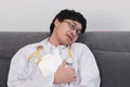 Tired young medicine Asian doctor asleep on couch at hospital