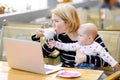 Tired young mother holding 6-month daughter and drinking coffee Royalty Free Stock Photo