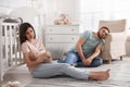 Tired young parents with baby sleeping on floor in children`s room Royalty Free Stock Photo