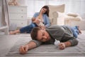 Tired young parents with their baby sleeping on floor in children`s room Royalty Free Stock Photo