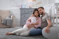 Tired young parents with their baby sleeping on floor in children`s room Royalty Free Stock Photo