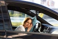 Tired young woman asleep on pillow on steering wheel, resting after long hours driving a car. Fatigue Royalty Free Stock Photo