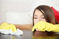 Tired young woman cleaning furniture table