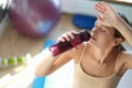 Tired young woman drinks water after training closeup Royalty Free Stock Photo