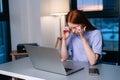 Tired young woman freelancer working on laptop rubbing eyes feeling discomfort pain at home office late in evening. Royalty Free Stock Photo