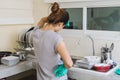 Tired young woman with gloves washing dishes Royalty Free Stock Photo