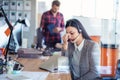 Tired young woman is sitting at the table at work in a call center. Royalty Free Stock Photo