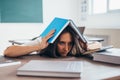 Tired young woman sleeping on desk with books Royalty Free Stock Photo