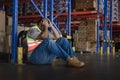 Tiredness from hard work concept. Warehouse worker laying on the floor in warehouse after tiring work Royalty Free Stock Photo