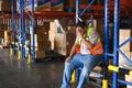Tiredness from hard work concept. Warehouse worker sitting on the floor in warehouse after tiring work Royalty Free Stock Photo
