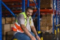 Tiredness from hard work concept. Warehouse worker sitting on the floor in warehouse after tiring work Royalty Free Stock Photo