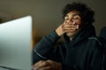 Tiredness. Sleepy young guy holding hand over his mouth while yawning. Male student studying using laptop, sitting in Royalty Free Stock Photo