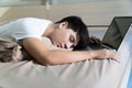 Tiredness young man working in bed with a laptop in front of him. Asian handsome man sleeping with tiredness in bed with