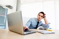 Tiresome businessman works on laptop