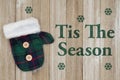 Tis the Season message with green and blue tartan mitten with wood