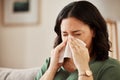 Tissue, blowing nose and woman in a living room with flu, cold and hay fever, crisis or viral infection in her home Royalty Free Stock Photo