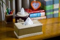 A tissue box on a wooden reading table.