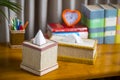 A tissue box on a wooden reading table.