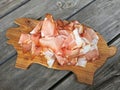Tissue thin slices Tyrolean Speak, Smoked bacon on wooden cutting board