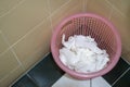 Tissue in the trash pink basket in bathroom