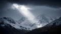 Title: Dramatic snowcapped mountain peaks with rays of sunlight breaking through dark storm clouds Royalty Free Stock Photo