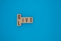 Title: Wooden cubes with the words GIVE and LIVE on smooth blue background Royalty Free Stock Photo