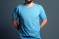 Young man in blank blue t-shirt on grey background. Mock up Ai generative Royalty Free Stock Photo