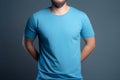 Young man in blank blue t-shirt on grey background. Mock up Ai generative Royalty Free Stock Photo