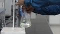 Titration reaction by shaking colorless liquid in conical flask under a burette