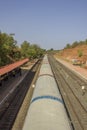 Indian train stands near the railway platform with waiting people, top view