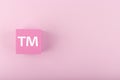 TM trademark sign on pink figure on bright pink background with copy space
