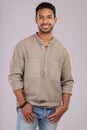 To approach life lightheartedly, is to own your power. Studio shot of a handsome young man posing against a grey Royalty Free Stock Photo