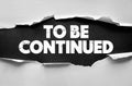 TO BE CONTINUED text on torn paper background. Concept design with ripped surface and grunge typography. Future progress, suspense Royalty Free Stock Photo