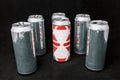 To be different. Stand out from the crowd. Empty open aluminium cans, inequality concept. On a black background